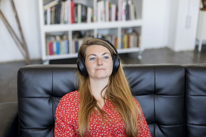 Blonde young woman relaxing and listening to music on headphones