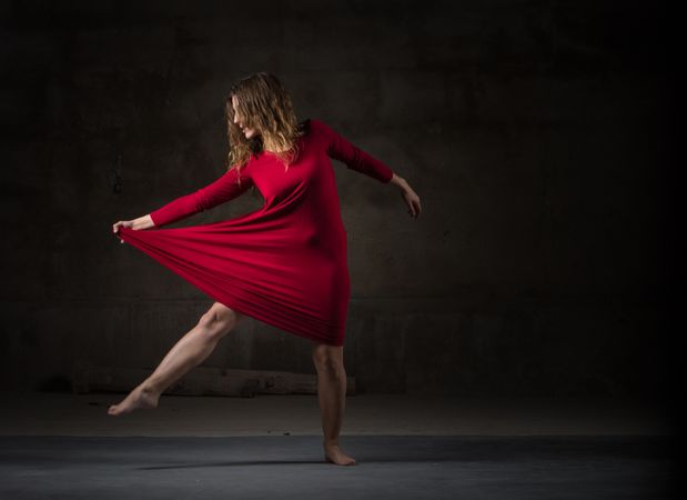 Young woman dancing in darkness
