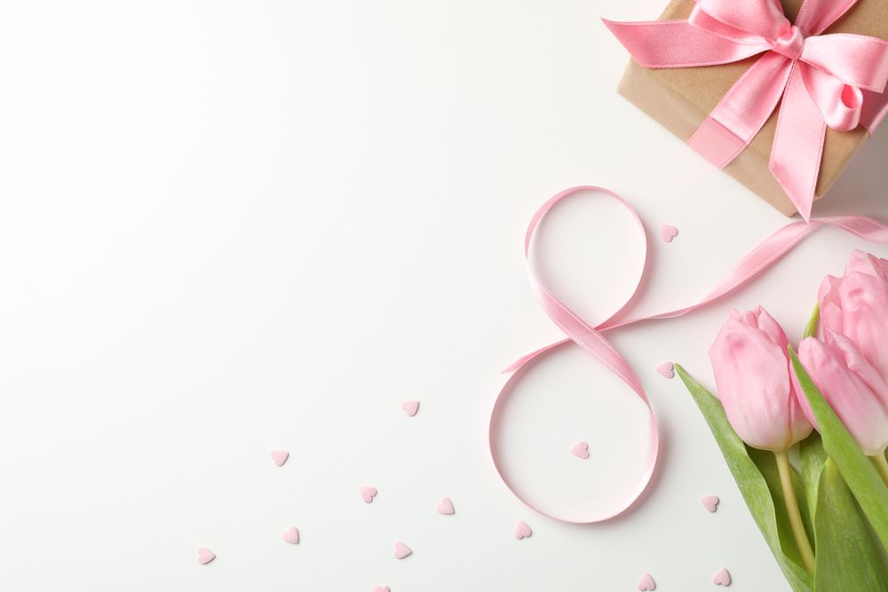 Tulips, gift box, eight made of ribbon and small hearts on light background, space for text