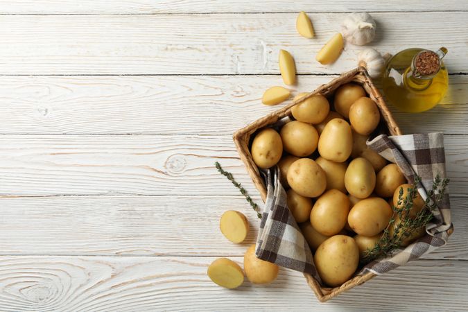 Looking down at box of potatoes on rustic background, copy space