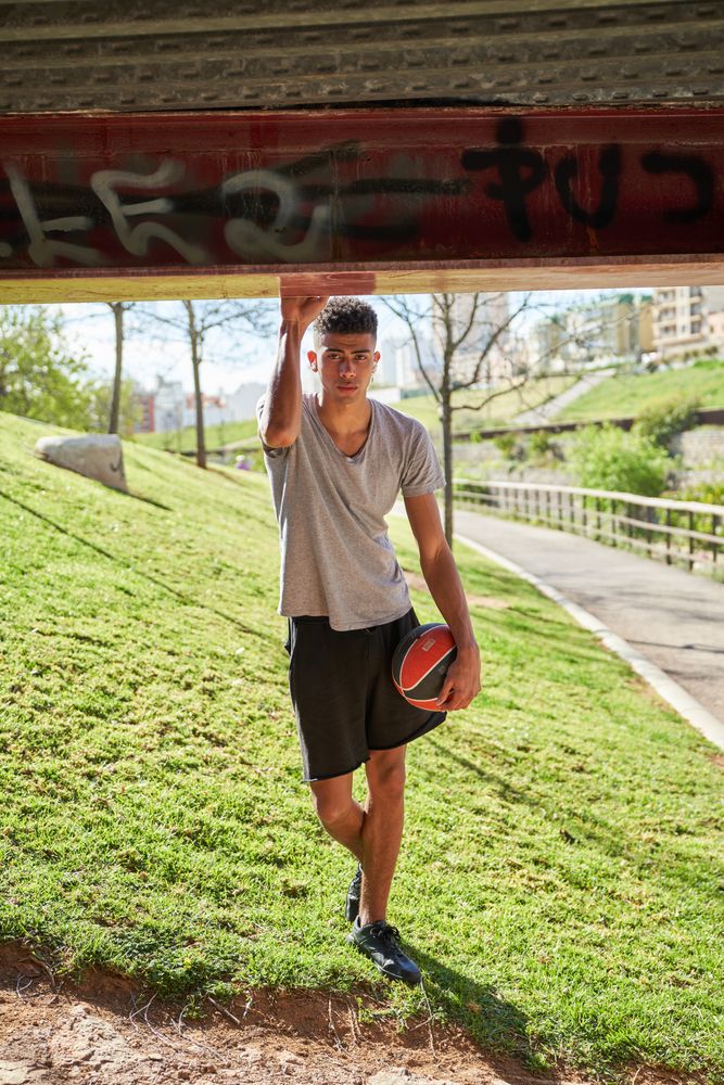 Hispanic man with ball on street