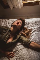 Tired woman lying on bed and looking up