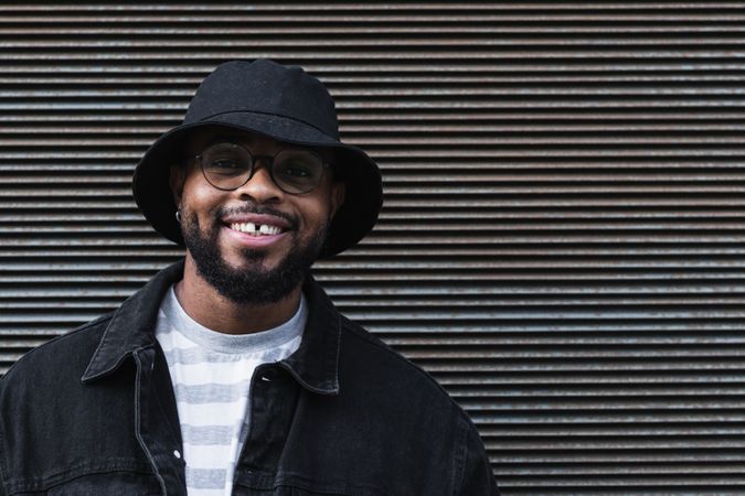 Smiling Black hipster man in hat looking at camera