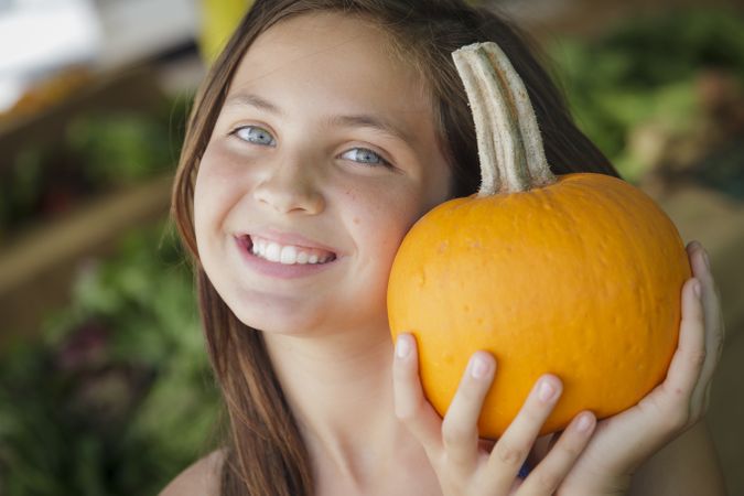 Girl Having Fun with the Pumpkins at Market
