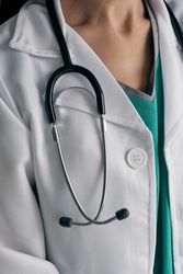 Crop physician in uniform with stethoscope at work