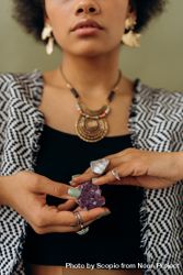 Black woman holding purple gemstone 4NlEl0