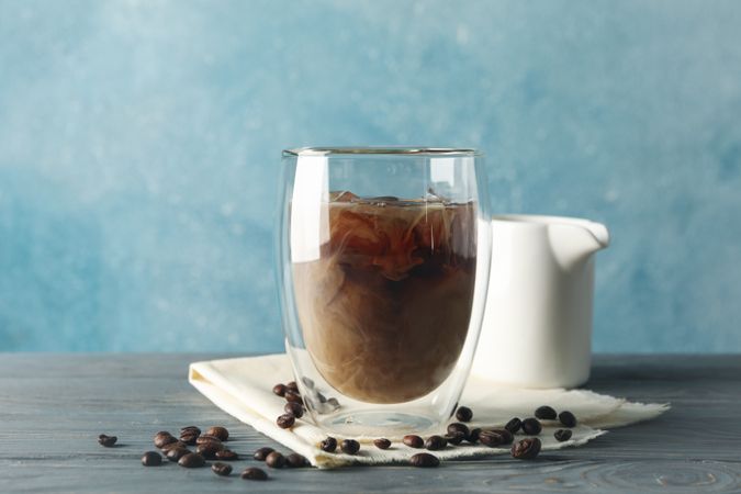 Composition with glass of ice coffee on wooden background