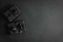 Gift boxes with dark bows on dark background