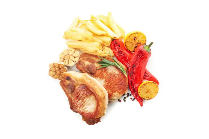 Fried pork steaks and vegetables isolated on light background. Grilled food