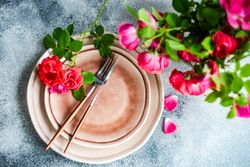 Top view of elegant table setting with roses and cutlery