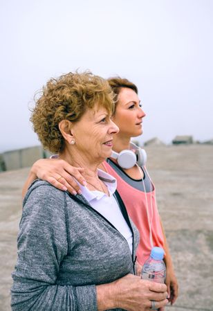 Mature and young sportswoman looking away
