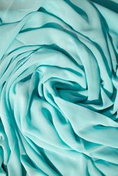 Spiral Twisted Turquoise wavy crumpled fabric with little sparkling dust, texture and  background.
