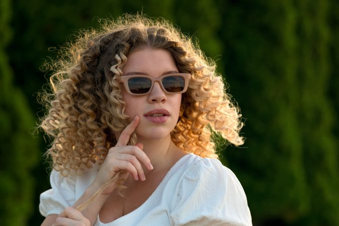 Portrait of serious curly haired woman outdoors