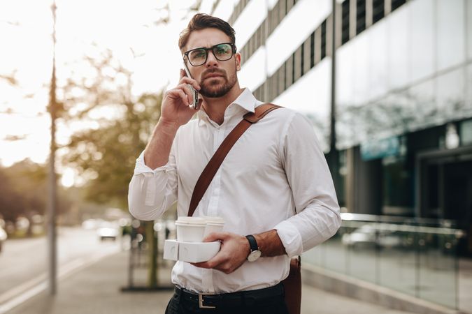 Businessman walking to office talking on mobile phone