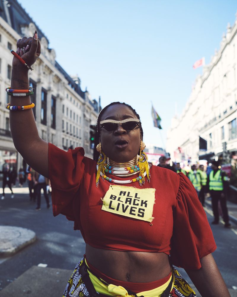 London, England, United Kingdom - March 19 2022: Black woman in African jewelry and raised fist