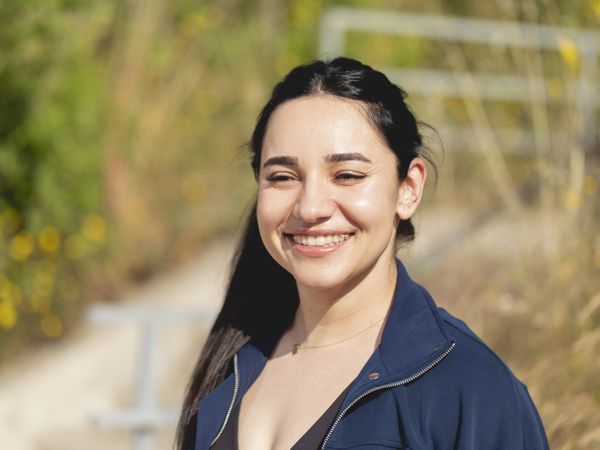 A young woman, wearing invisible aligners for orthodontic, smiles during a walk in the park