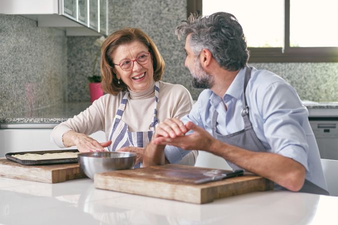 Content mother with son cooking at table