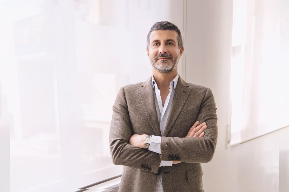 Smiling mature businessman with a beard standing in his office