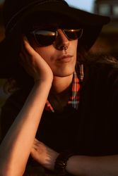 Dreaming stylish woman in sunglasses and hat