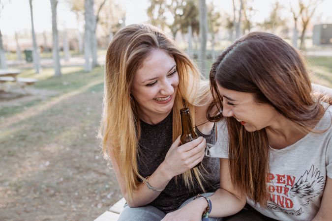 Girl friends hugging and laughing in park