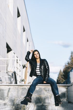 Young woman posing with skateboard