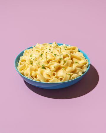 Pasta alfredo dish isolated on a purple background