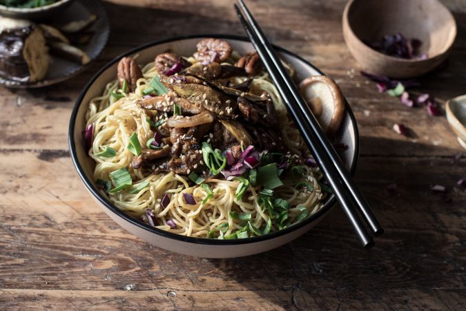 Miso noodles with egg plants and shiitake in bowl on table