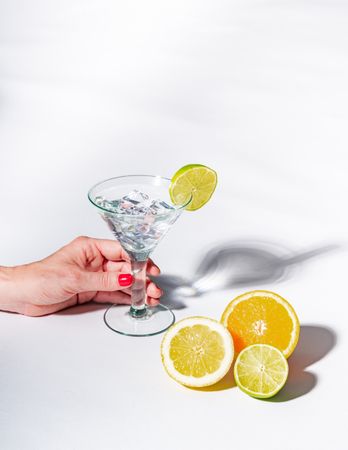 Cocktail glass with ice cubes and sliced citrus