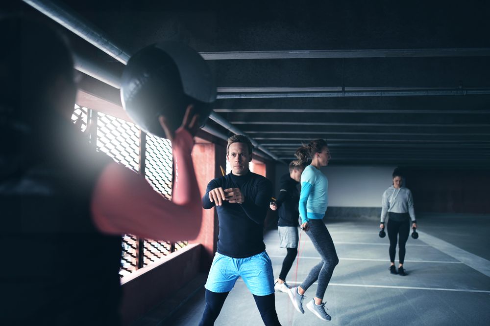 People doing circuit training with medicine ball, kettle bell and skipping rope