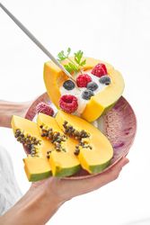 Crop person with plate of papaya dessert