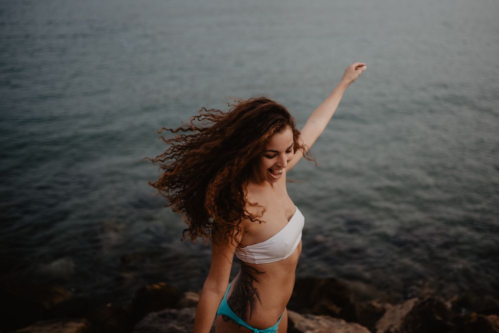 Smiling female dancing near sea