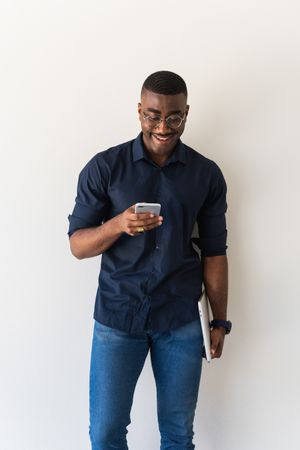 Happy Black guy with phone and laptop