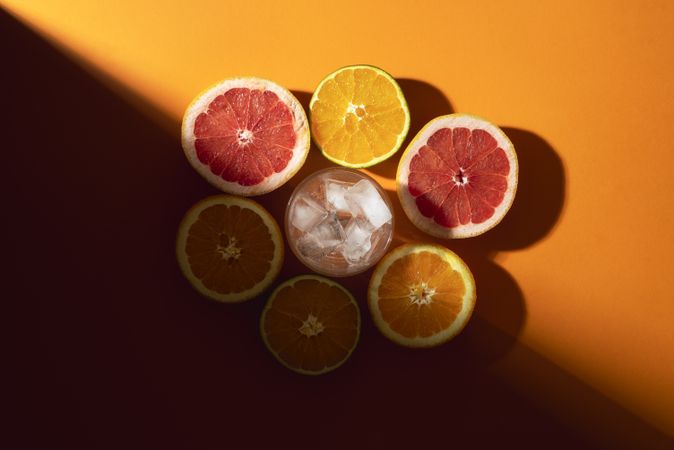 Halved citrus fruits on orange background