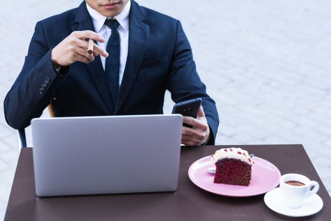 Businessman smoking cigar in street cafe