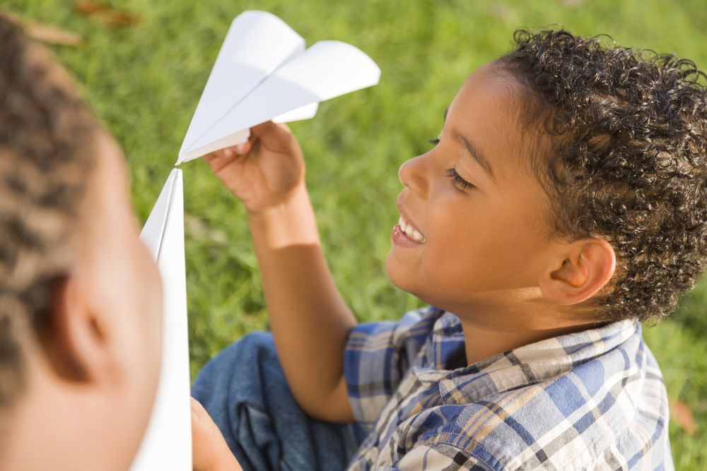 Happy Father and Son Playing with Paper Airplanes