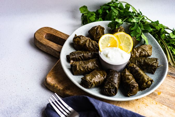 Plate with traditional Georgian stuffed grape leaves served with knife and fork