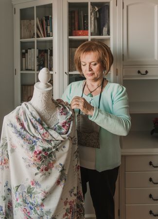 Dressmaker adjusting apparel on mannequin