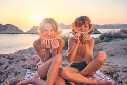Happy brother and sister during picnic at seaside