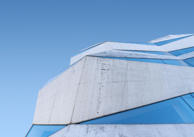 Side of geometric building against a blue sky
