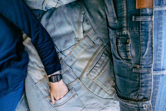 Anonymous person lying on denim with hand in pocket