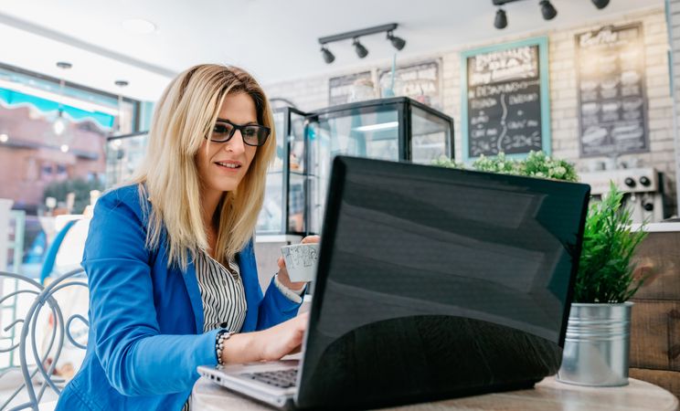 Woman drinking coffee and chatting with the laptop