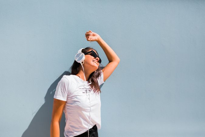 Cheerful casual woman in sunglasses standing on city street