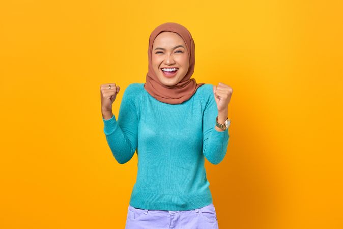 Smiling Muslim woman celebrating a win