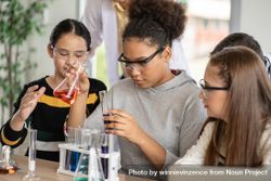 Group of female students in science class doing chemical experiment in laboratory 5zxlPb