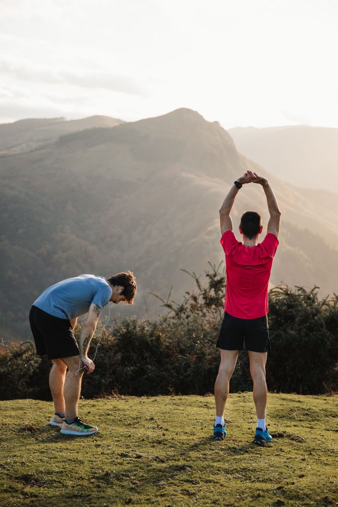 Sportsmen stretching after running in mountains