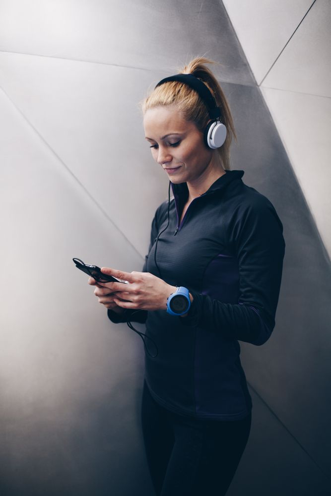 Woman with sportswear listening to music with headphones
