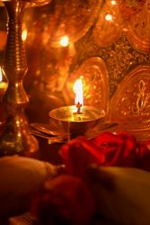 Lit diya surrounded by roses