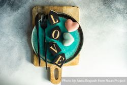 Teal plate with the word "love" and heart decorations on cutting board 4Oddjo