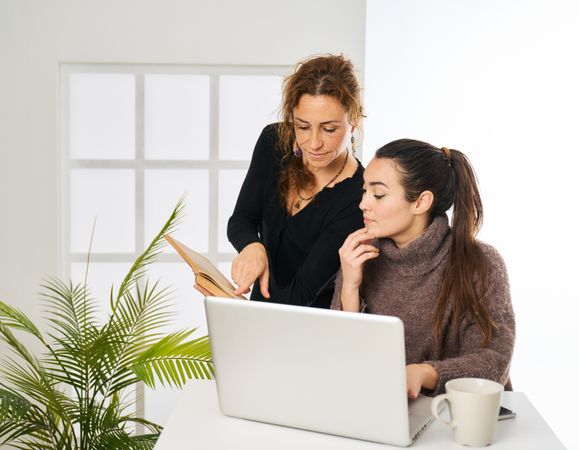 two women working in the office looking up customer data in the
