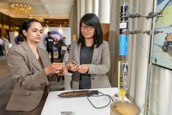 Two women with an engineering experiment at a conference 5XYJV4